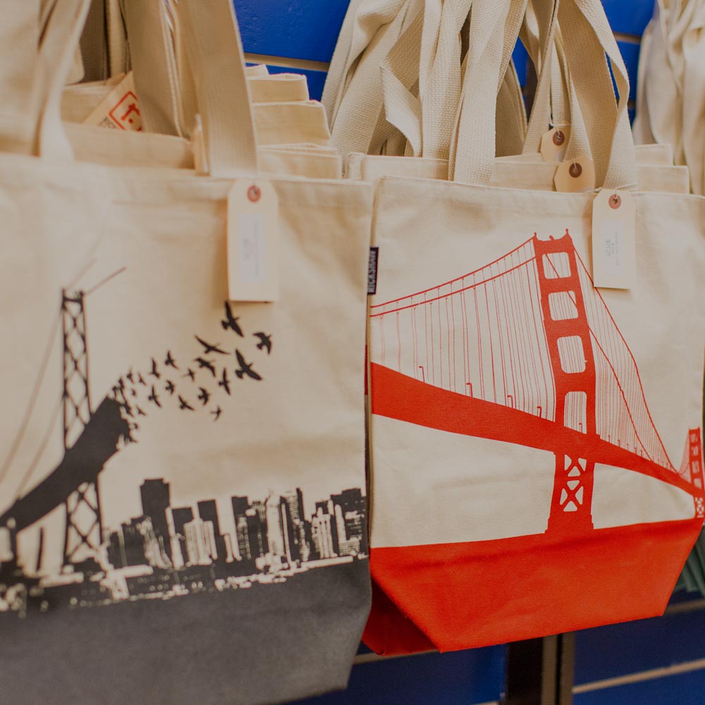 Stylish tote bags featuring the Golden Gate Bridge and bird motifs.